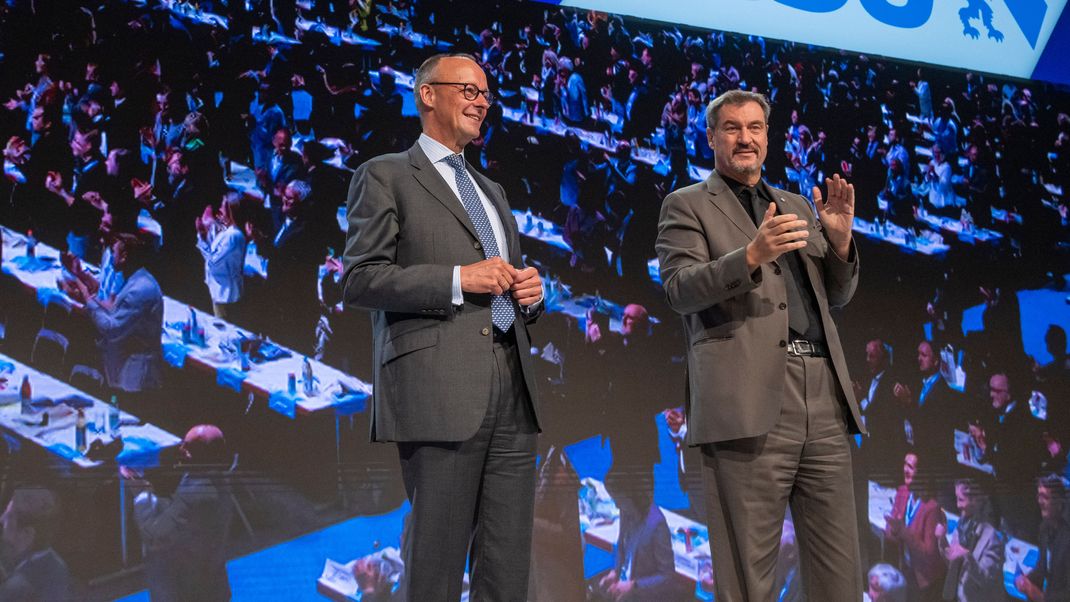 Friedrich Merz (l), CDU-Bundesvorsitzender und Unionsfraktionsvorsitzender, und Markus Söder (r), Vorsitzender der CSU, stehen auf dem Parteitag der CSU zusammen auf der Bühne.