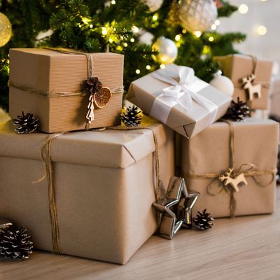 close up of beige gift boxes near decorated christmas tree