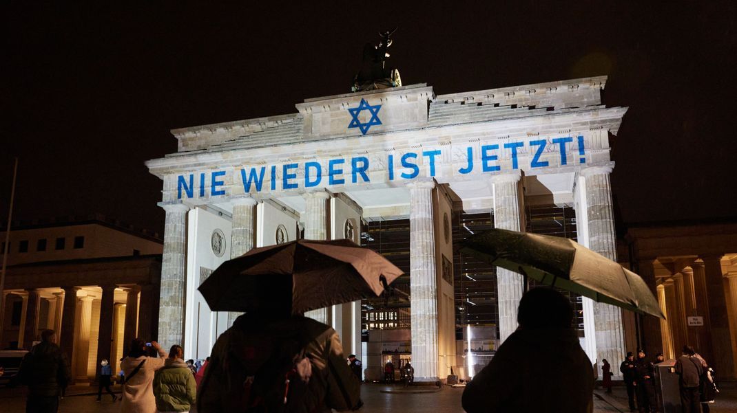 Der Schriftzug "Nie wieder ist jetzt" wird zum 85. Jahrestag der Pogromnacht an das Brandenburger Tor projiziert. 