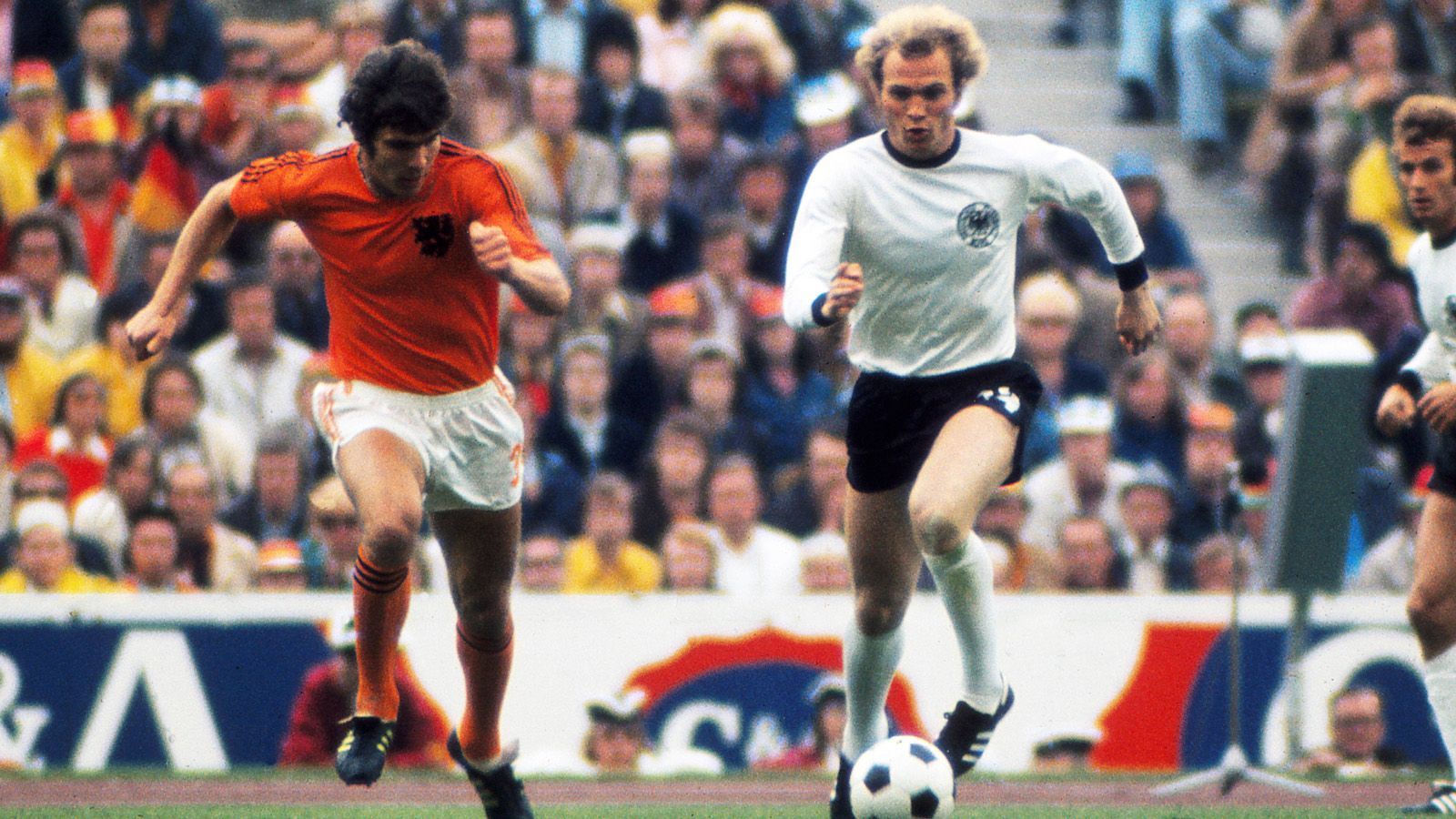 
                <strong>Kurze, aber erfolgreiche DFB-Karriere </strong><br>
                Zwischen 1972 und 1976 trägt Uli Hoeneß insgesamt 35 Mal das Trikot der deutschen Nationalmannschaft und schießt insgesamt fünf Tore. Trotz der vergleichsweise kurzen Dauer gewinnt Hoeneß 1972 die Europameisterschaft und wird zur Krönung als 22-Jähriger 1974 mit der DFB-Auswahl Weltmeister im eigenen Land. Bei der WM kommt er in allen sieben Spielen zum Einsatz.
              