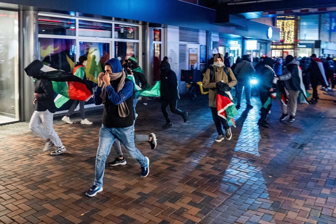 Demonstranten laufen in Amsterdam mit palästinensischen Fahnen bei einer pro-palästinensischen Demonstration während des Spiels Ajax - Maccabi Tel-Aviv.