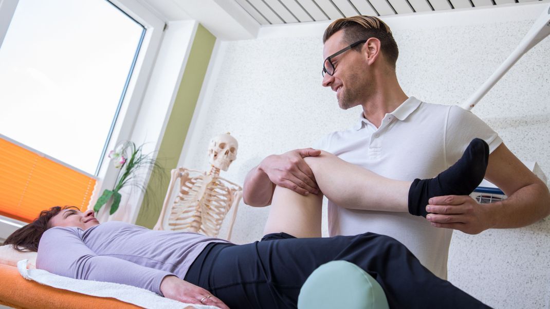 Ein Physiotherapeut behandelt eine Patientin 