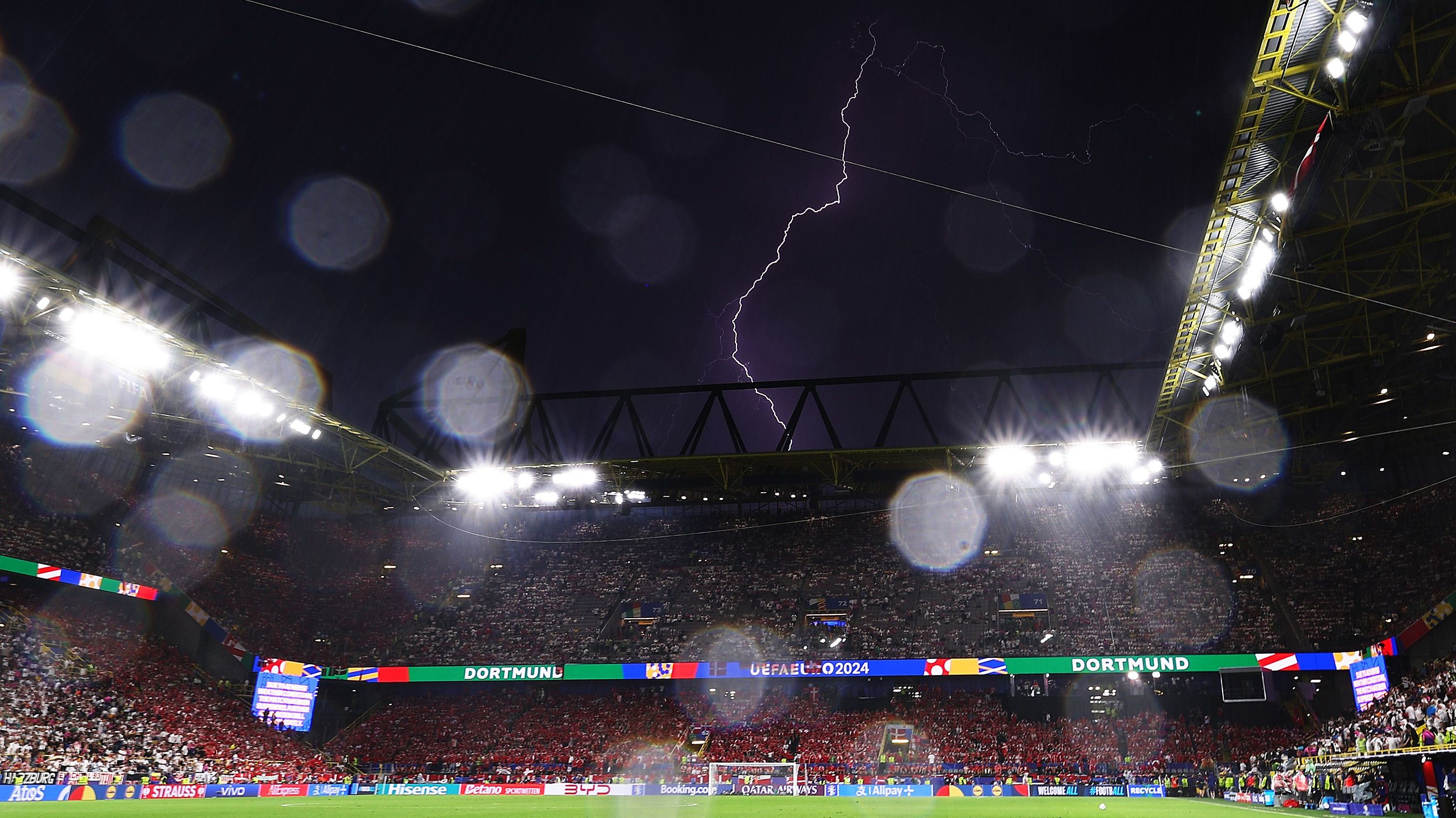 <strong>Gewitter sorgt für Spielunterbrechung</strong><br>Deutschlands Achtelfinal-Spiel gegen Dänemark bei der EM 2024 musste am Samstagabend in Dortmund bereits in der ersten Halbzeit für gut 25 Minuten unterbrochen werden. Der Grund: Ein heftiges Gewitter und extrem starke Regenschauer. Doch davon ließen sich die Fans beider Teams die Feierlaune nicht verderben. <strong><em>ran</em></strong> zeigt die Bilder der Dortmunder Regen-Party.&nbsp;