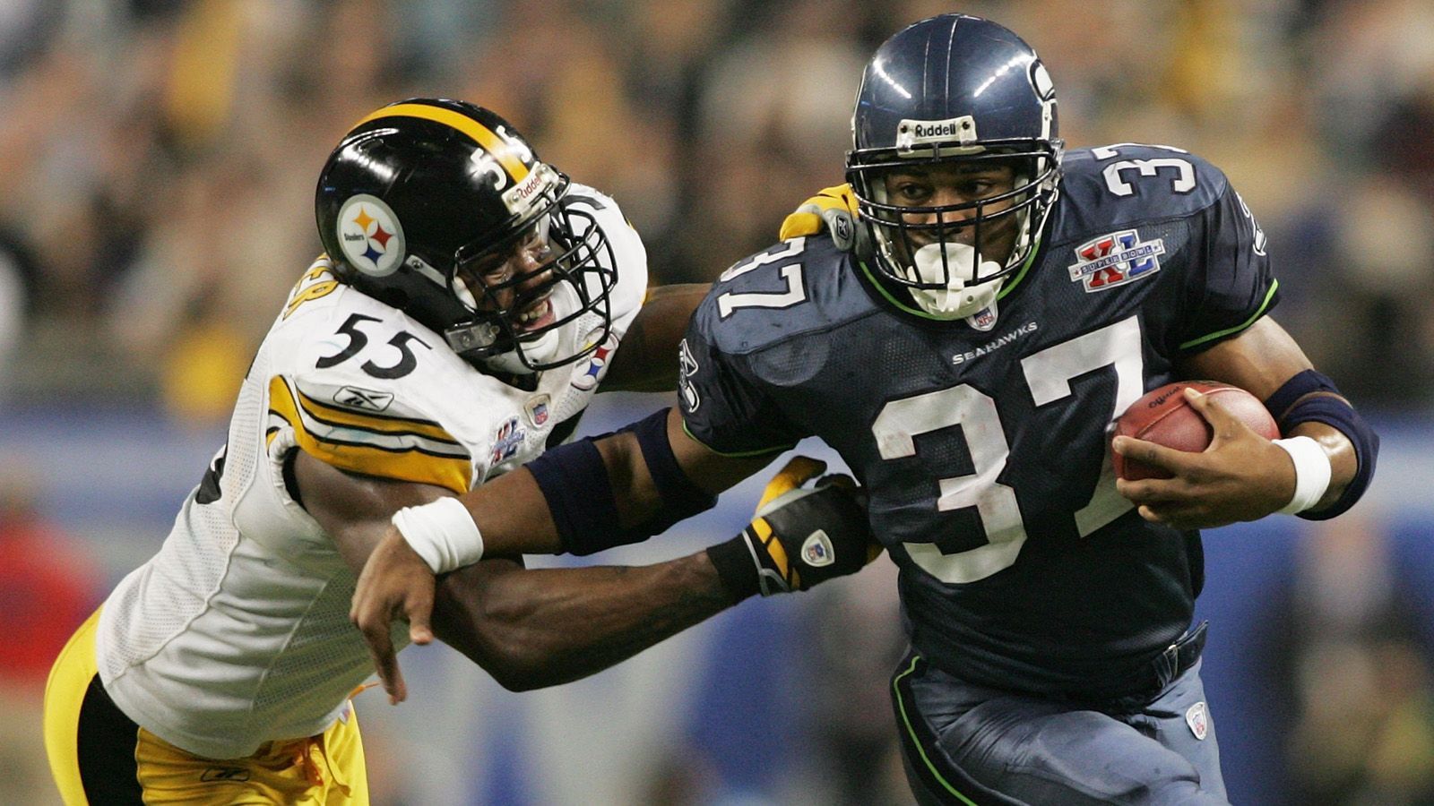 
                <strong>Shaun Alexander, Seattle Seahawks - Super Bowl XL</strong><br>
                Shaun Alexander hatte 2005 eine Saison für die Geschichtsbücher. Der Running Back der Seattle Seahawks wurde zum ersten MVP der Franchise-Geschichte der Seattle Seahawks. 27 Touchdowns und 1.880 Rushing Yards waren jeweils Liga-Bestwerte. Dazu verzeichnete er zehn Spiele mit 100 oder mehr Rushing Yards. Zusammen mit Quarterback Matt Hasselback leitete er die beste Offense der NFL, die auch den Scoring-Titel gewann. Im Super Bowl XL trug er zwar 20 Läufe und 95 Yards bei, dennoch unterlagen die Seahawks der Power-Defense der Pittsburgh Steelers um Ben Roethlisberger mit 10:21. Alexander spielte danach noch drei Jahre in der NFL, kam an seine Leistungen aber nie wieder heran.
              