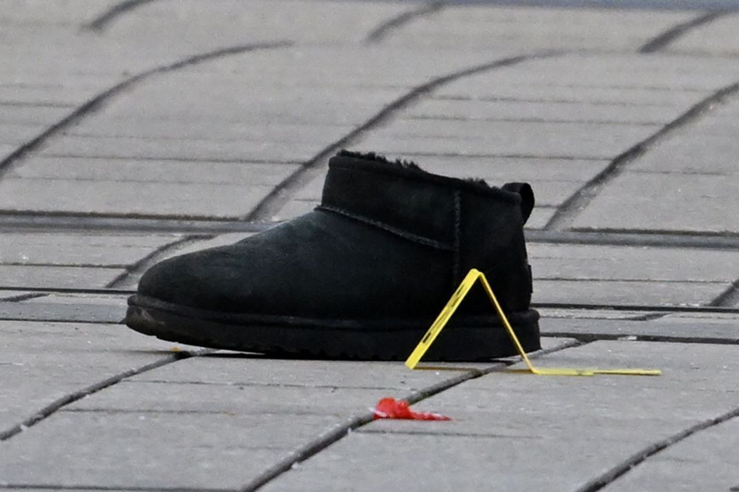 Ein Schuh mit einer Markierung der Polizei ist in der Innenstadt zu sehen. Nach einem Vorfall mit einem Auto in der Mannheimer Innenstadt mit mindestens zwei Toten und mehreren Verletzten ist der mutmaßliche Fahrer nach Polizeiangaben festgenommen worden. 