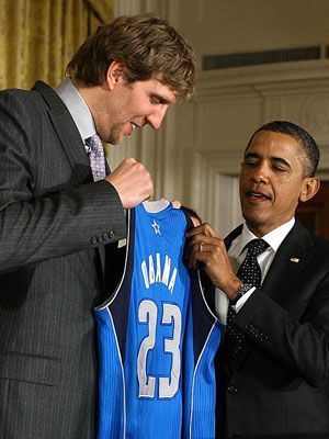 
                <strong>Dirk Nowitzkis Karriere: Audienz bei Obama</strong><br>
                Wenige Monate nach der Meisterschaft hatte Nowitzki als Kapitän die Ehre, US-Präsident Barack Obama bei der obligatorischen Audienz im Weißen Haus ein Mavericks-Trikot zu überreichen. Im Jahr der Meisterschaft wurde Nowitzki im Übrigen "Best Male Athlete" in den USA und "Sportler des Jahres" in Deutschland.
              