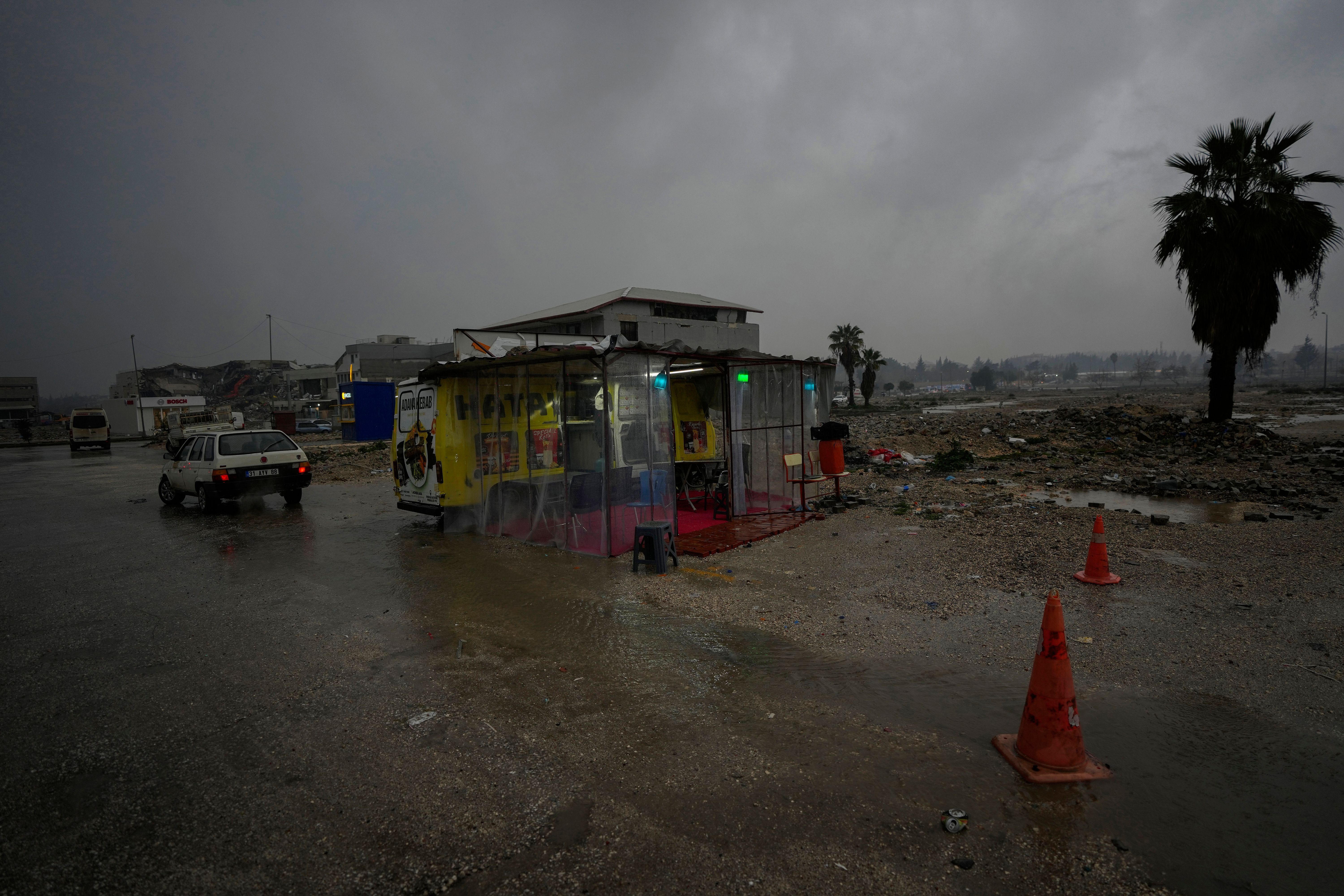 Türkei, Antakya: Ein Imbiss-Wagen steht inmitten der Überreste zerstörter Gebäude.