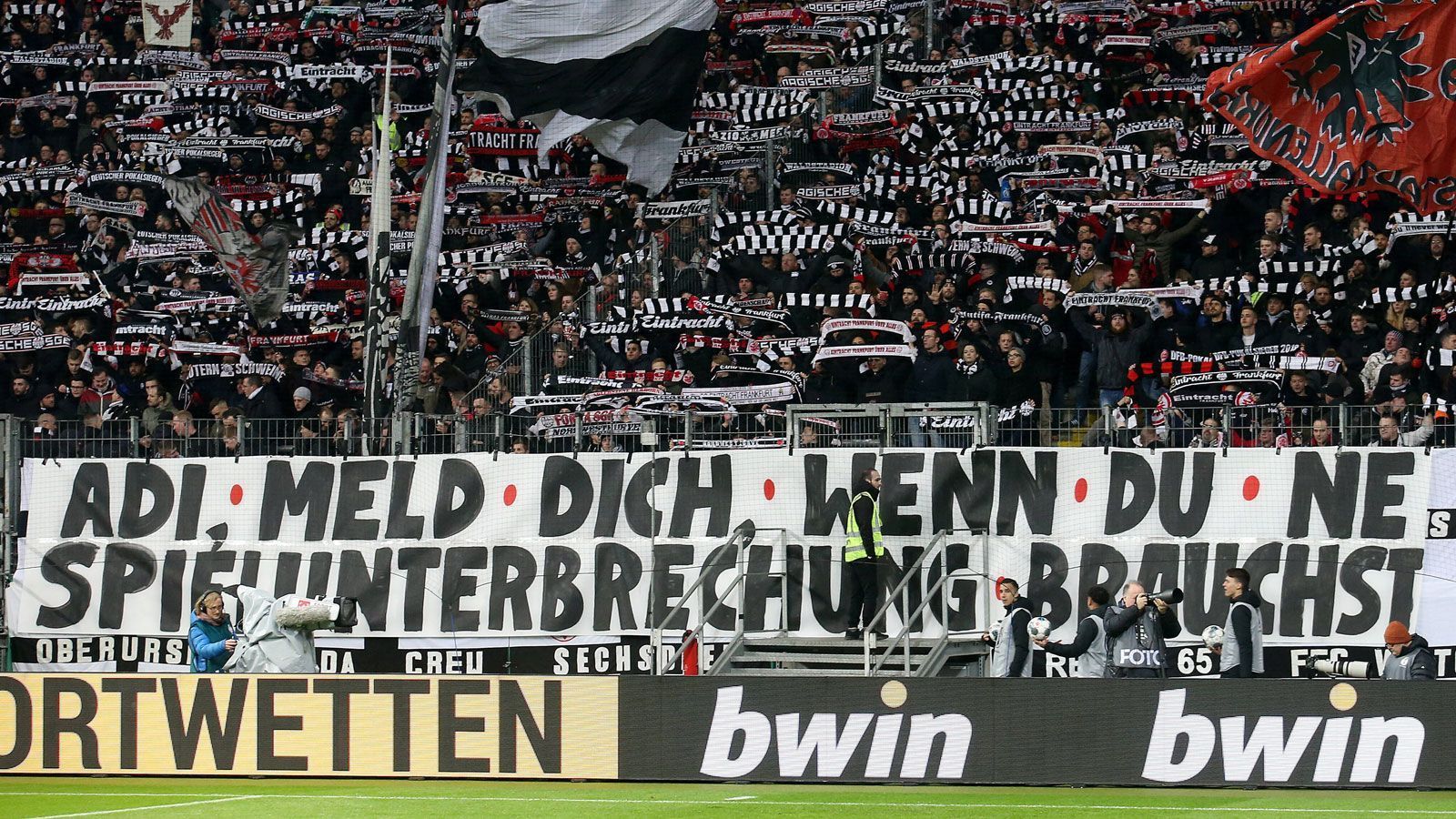 
                <strong>Fans von Eintracht Frankfurt</strong><br>
                "Adi, meld dich, wenn du eine Spielunterbrechung brauchst!" - Die Fans von Eintracht Frankfurt meldeten sich in ihrer Nordwestkurve mit einem speziellen Angebot: Sie boten ihrem Trainer Adi Hütter an, Spielunterbrechungen taktisch einzusetzen. Auch hier eine Anspielung zu den Plakaten in der "Causa Hopp".
              