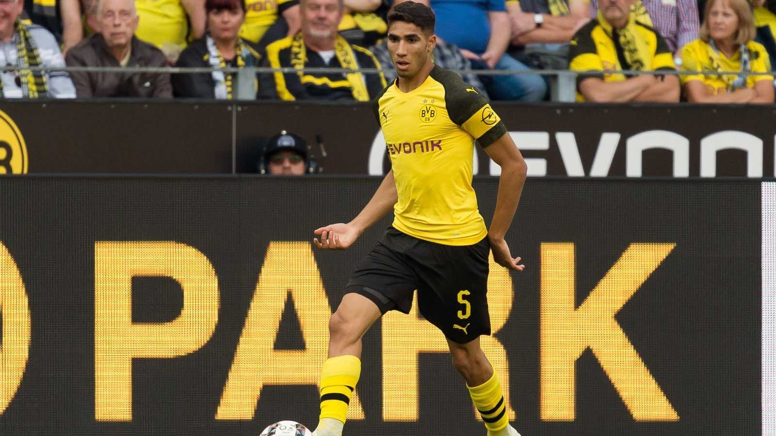 
                <strong>Abwehr - Achraf Hakimi (Borussia Dortmund)</strong><br>
                Der BVB hat im Sommer 2018 bei den Transfers ein richtig gutes Händchen bewiesen. Ein Beleg dafür sind die guten Leistungen von Real-Leihgabe Achraf Hakimi. Der marokkanische Nationalspieler und WM-Teilnehmer kam in bislang drei Bundesliga-Spielen als Backup bzw. Konkurrent von Lukasz Piszczek zum Einsatz und verdeutlichte dabei vor allem seine Offensivqualitäten. In 270 Minuten steuerte der 19 Jahre alte Rechtsverteidiger ein Tor und zwei Vorlagen bei. Gut für Borussia Dortmund, dass man das Juwel bis 2020 ausgeliehen hat.
              