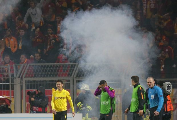 
                <strong>Spielunterbrechungen in Halbzeit Zwei</strong><br>
                In der ersten Hälfte heizte sich die Stimmung bereits auf, nach den Toren in der zweiten Halbzeit eskaliert die Situation. Aus dem Galatasaray-Block fliegen Rauchbomben und Feuerwerkskörper - einige davon landen auch im Dortmunder Fanblock.
              