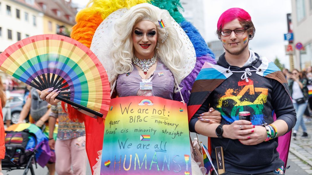 "We are not: queer, BIPoC, non-binary, trans, cis, minority, straight. We are all HUMANS" steht auf einem Schild der Dragqueen Zoey Rachel Pride.