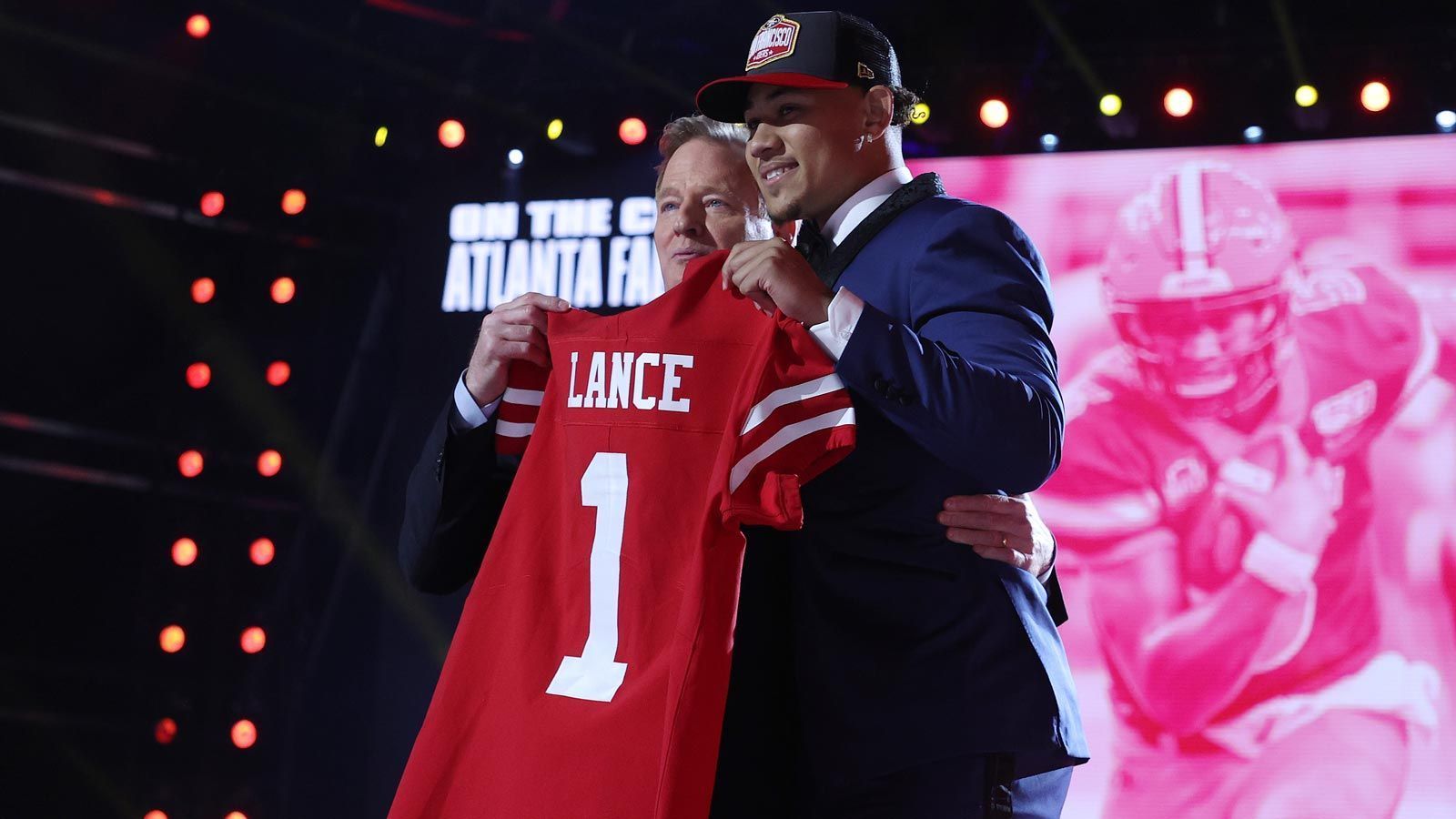 
                <strong>Platz 10 - San Francisco 49ers</strong><br>
                Nach langer Geheimniskrämerei verkündeten die 49ers an der 3. Stelle des Drafts ihren neuen Quarterback: Trey Lance (im Bild, rechts). Der 20-Jährige gilt als Projekt-Spielmacher und wird wohl vorerst hinter Routinier Jimmy Garoppolo Platz nehmen. Mit Guard Aaron Banks, Running Back Trey Sermon und Cornerback Ambry Thomas stopfen die "Niners" zudem wichtige Löcher in ihrem Roster. Wie bei vielen anderen Teams ist der Erfolg in der kommenden Saison auch hier mit Quarterback-Position verknüpft. 
              