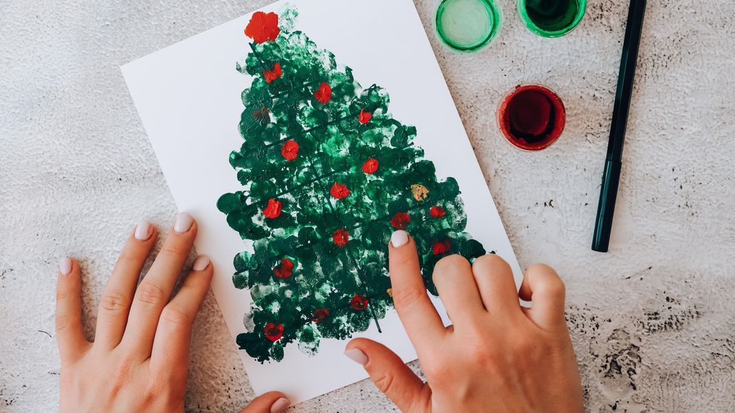 Bei diesem weihnachtlichen Motiv aus Fingerabdrücken können auch schon die kleinsten Familienmitglieder mitmachen.