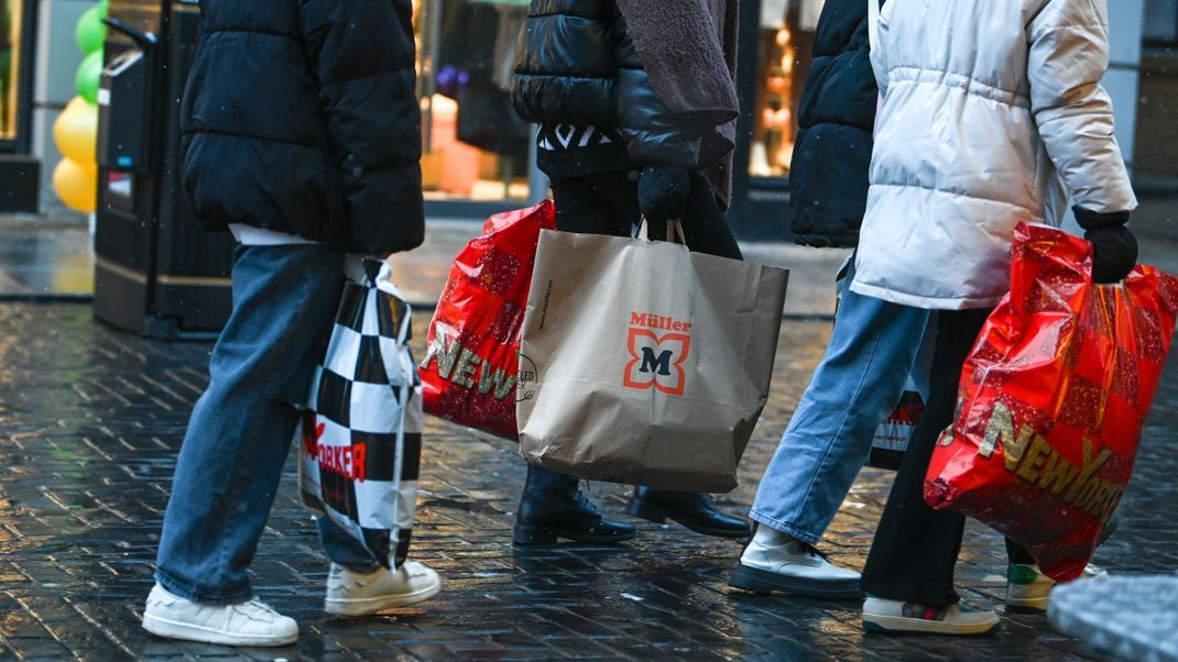 10.12.2022, Sachsen-Anhalt, Halle (Saale): Passanten gehen mit Einkaufstüten durch die Innenstadt. Am dritten Adventswochenende zog es viele Menschen zum Einkaufen in die Innenstadt. Foto: Heiko Rebsch/dpa +++ dpa-Bildfunk +++