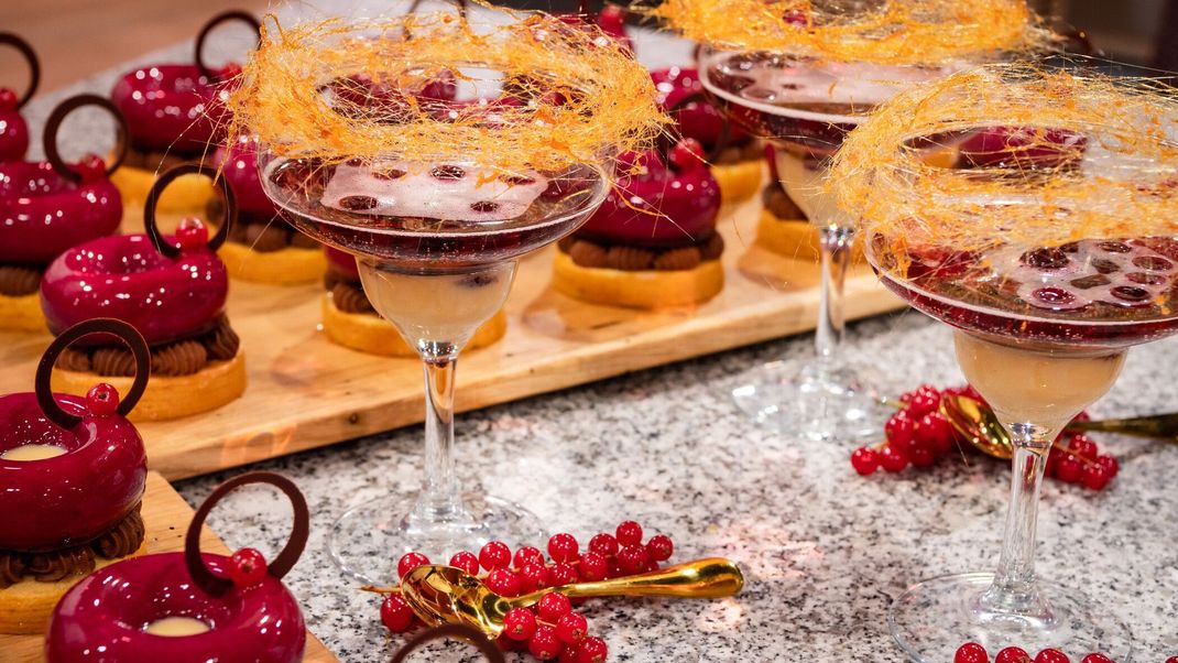 Baumkuchen-Törtchen mit Schokoladen-Sahne, Cassis-Mousse und Eierlikör und Drink aus Eierlikör, Champagner und Cassislikör