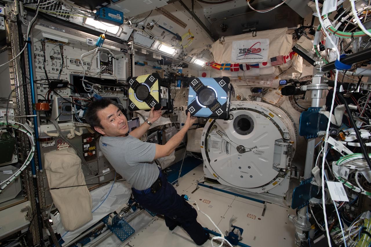Die fliegenden Astrobees an Bord der ISS sehen nicht aus wie Tiere. Hier ist der würfelförmige Roboter mit einem Astronauten im Einsatz.