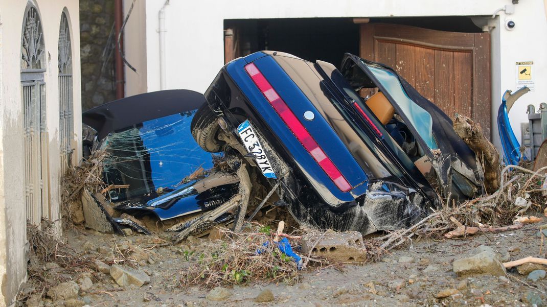 Zwei von Schlamm bedeckte Autos liegen vor einem Wohnhaus in Ischia.
