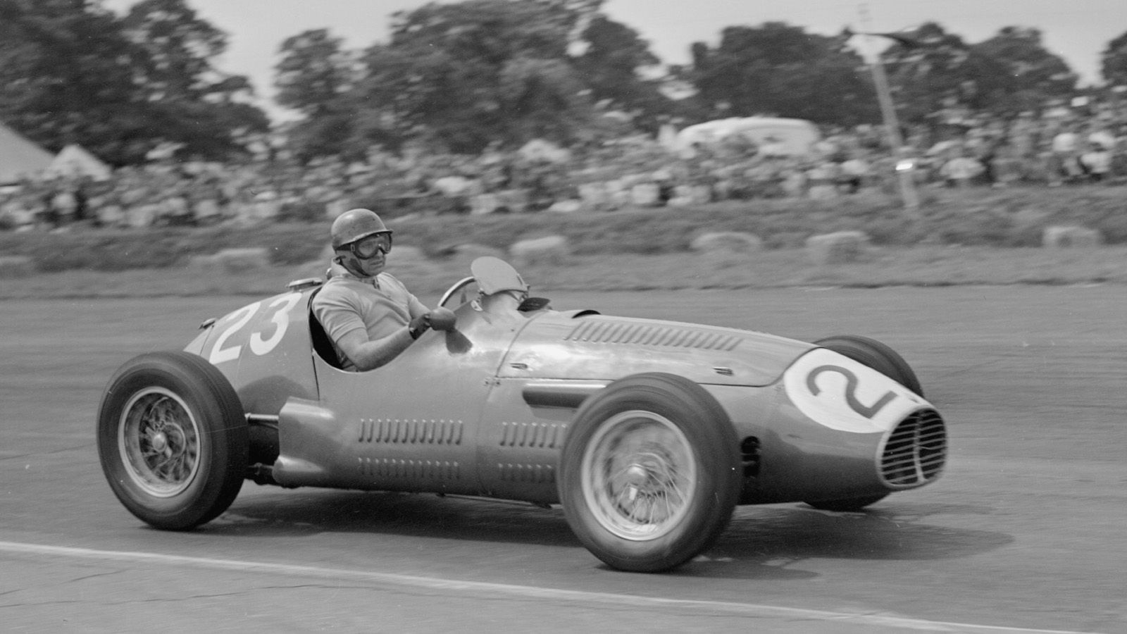 
                <strong>BRM (1953) </strong><br>
                Juan Manuel Fangio (1911 - 1995), der legendäre Rennfahrer aus Argentinien, sitzt im Jahr 1953 beim Großen Preis von Silverstone in einem Fahrzeug von British Racing Motors (BRM). Fangio prägte die Anfangsjahre der Formel 1 und gewann fünf Fahrer-Weltmeisterschaften. Erst 2003 wurde sein Rekord von Michael Schumacher übertrumpft. Die Fahrzeuge in den 1950er Jahren erinnern von der Optik an eine Zigarre, die Motoren sitzen noch vor dem Fahrercockpit.
              