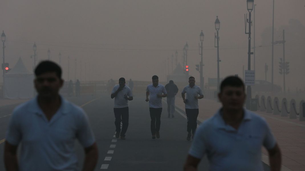 Jogger bei dichtem Smog im indischen Neu Delhi