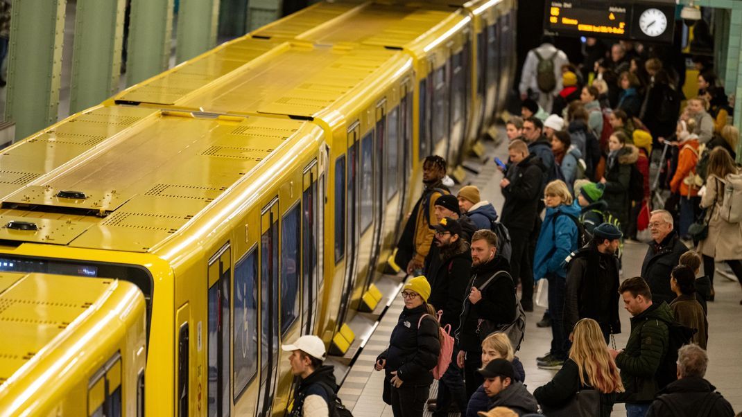 Menschen warten am Alexanderplatz in Berlin auf die U-Bahn. 