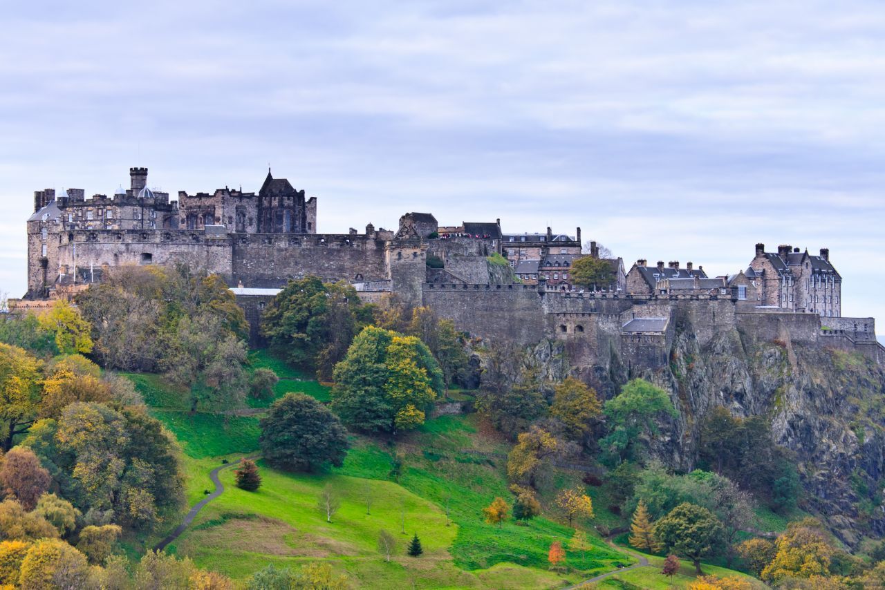 Eine der berühmtesten Burgen Schottlands thront auf dem 120 Meter hohen Castle Rock mitten im Zentrum. Nach 3 Seiten hin fällt der Fels beinahe senkrecht ab, über die Ostseite jedoch lässt sich Edinburgh Castle problemlos zu Fuß erreichen. Die St Margaret's Chapel aus dem 12. Jahrhundert ist in Teilen noch im Original-Zustand erhalten. Mit einem Audio-Guide am Ohr können Besucher:innen bei einer Tour durch die Anlage den Lege