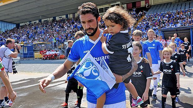 
                <strong>Aytac Sulu (SV Darmstadt 98)</strong><br>
                Aytac Sulu beim SV Darmstadt 98 ohne Kapitänsbinde? Undenkbar! Der 29-Jährige führt das Team an, seitdem er 2013 bei den Hessen anheuerte - nach der 3. und 2. Liga in den nächsten Monaten also auch in der Bundesliga.
              