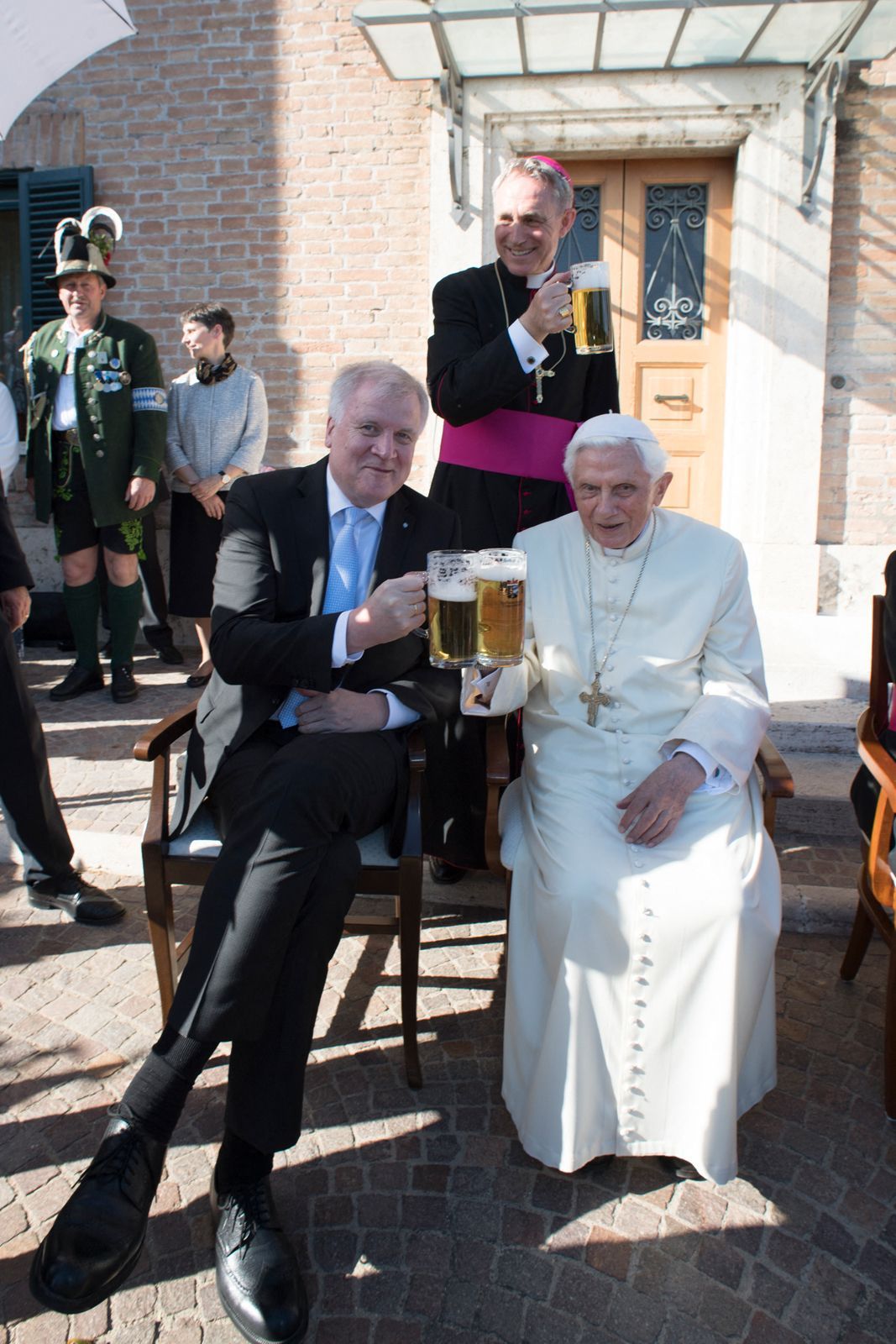 Der emeritierte Papst Benedikt XVI. trinkt mit seinem Privatsekretär Georg Gänswein und dem damaligen bayerischen Ministerpräsidenten Horst Seehofer während seiner 90. Geburtstagsfeier ein Glas Bier.
