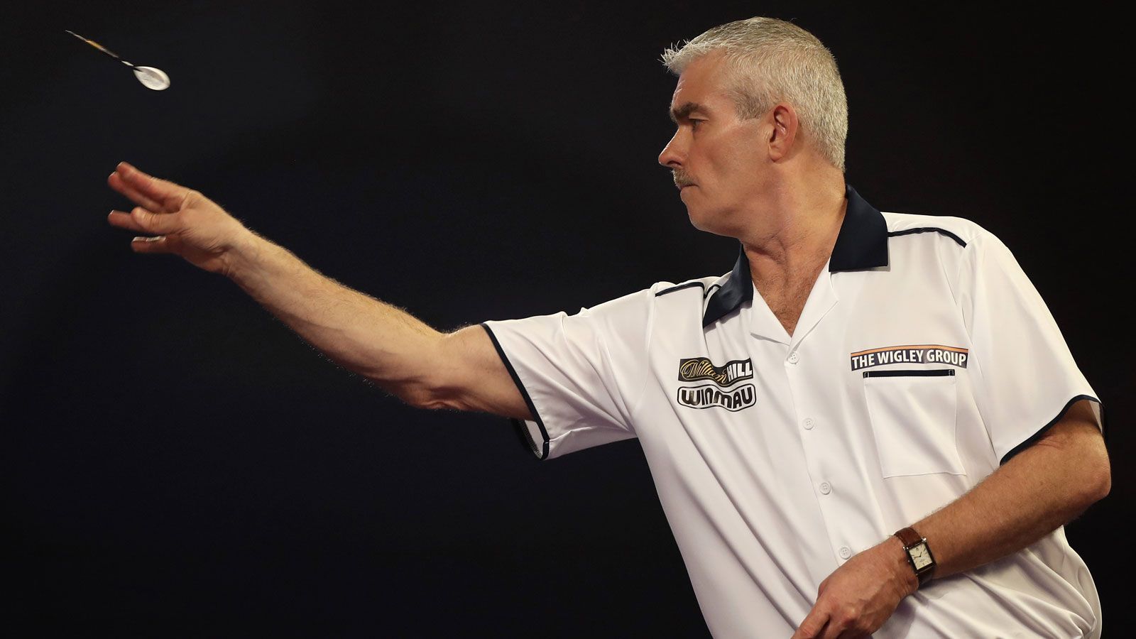 <strong>Steve Beaton (England) - Bronzed Adonis</strong><br>
                Der "braun gebrannte Schönling" bekam seinen Spitznamen wegen seiner stets gebräunten Haut. Diese holte er sich unter anderem infolge seiner Darts-Trainings auf Teneriffa.
