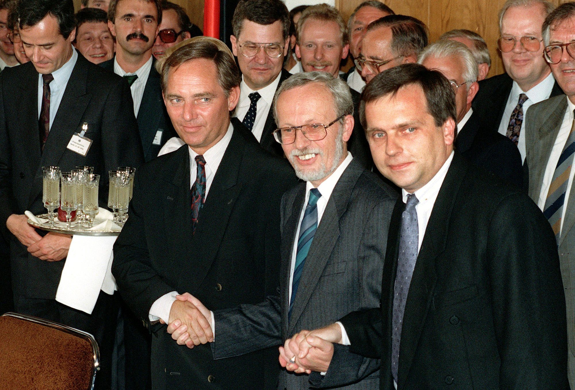 3. August 1990: Der damals westdeutsche Staatssekretär Wolfgang Schäuble (links), sein ostdeutscher Amtskollege Günther Krause (rechts) und der ostdeutsche Ministerpräsident Lothar de Maizière (Mitte) reichen sich nach Unterzeichnung des deutschen Einigungsvertrags symbolisch die Hand.