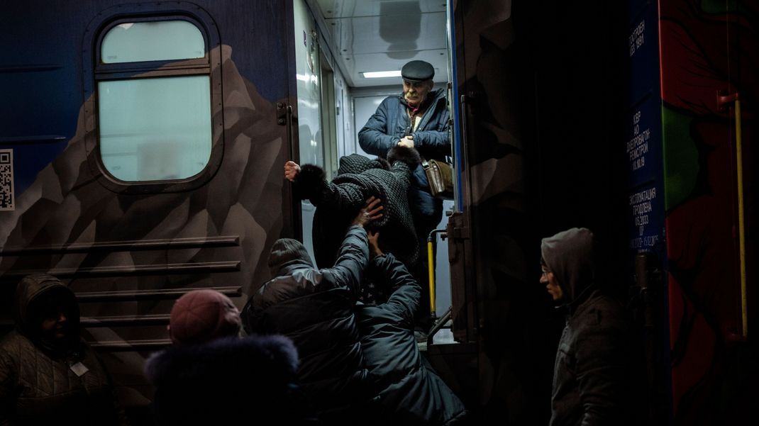 Ukrainer:innen steigen im Bahnhof von Cherson in den Zug Richtung Kiew. Aus Angst, den Winter nicht zu überstehen, evakuieren die Behörden die Region.