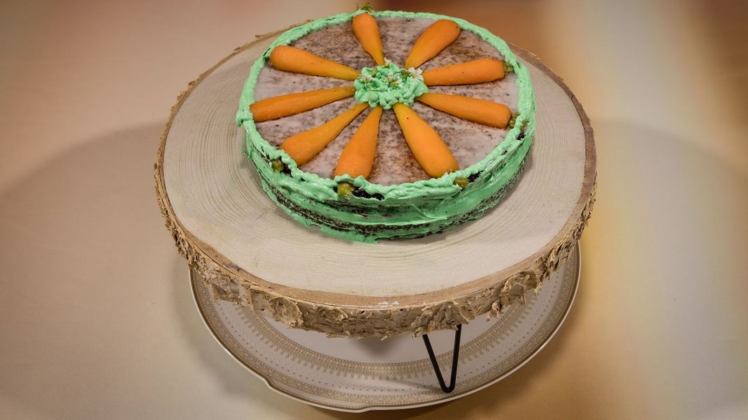 Rüblikuchen mit Brandy-Karamell-Buttercreme, Himbeer-Nuss-Crunch und geschnitzten Mini-Rüben