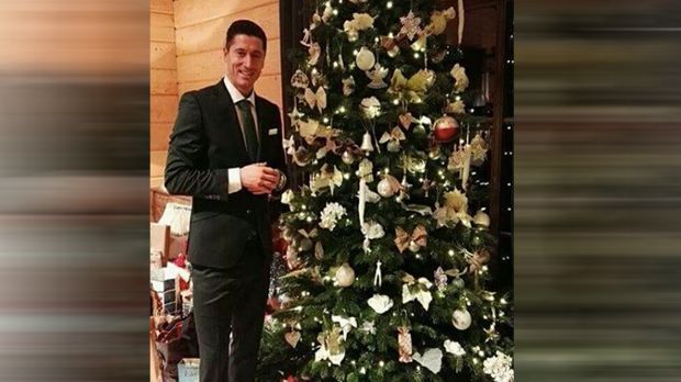 
                <strong>Robert Lewandowski</strong><br>
                Feierlich gekleidet mit Anzug und Krawatte posiert Bayern-Stürmer Robert Lewandowski neben dem festlich geschmückten Tannenbaum. Das Dekorieren hat der Pole wohl aber eher seiner Frau Anna überlassen ...
              