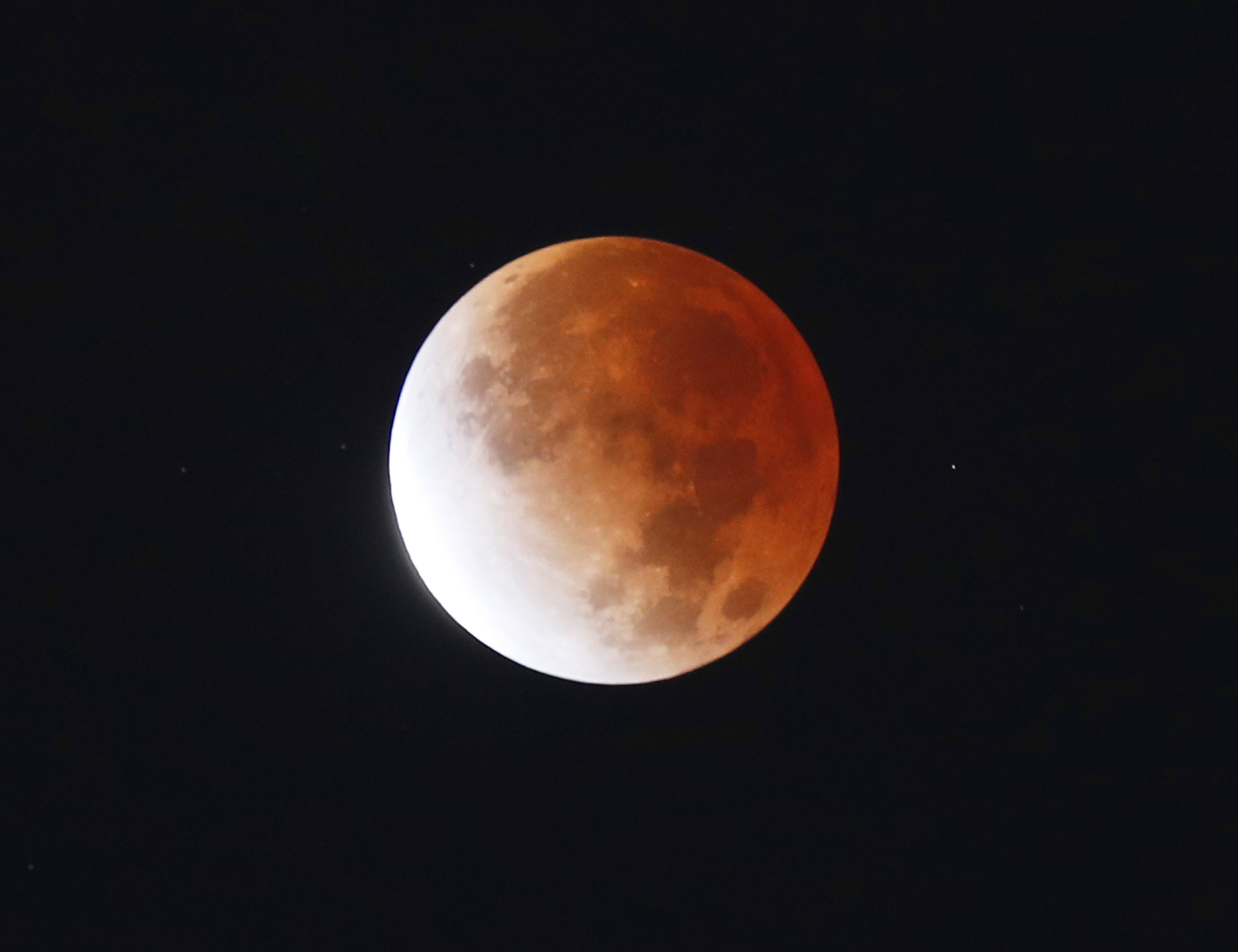 Mondfinsternis über New York im November 2021. Bei der Mondfinsternis steht der Mond im Kernschatten der Erde. Durch das Streulicht taucht er in einen blutroten Schimmer. Auf dem ersten sieht man, wie er leuchtet, wenn er gänzlich in den Schatten der Erde eintaucht. Auf diesem Bild steht er teilweise im Schatten.