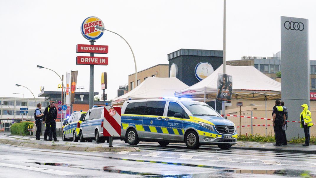 Einsatzkräfte sichern das Areal, nachdem ein Mann zwei ihm bekannte Menschen auf der Straße mit einem Messer angegriffen und verletzt hat.