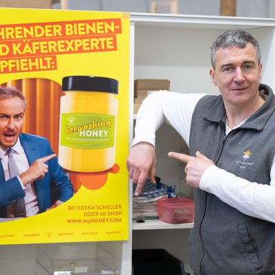 Rico Heinzig steht neben einem Plakat mit dem Foto des Moderators Jan Böhmermann. Der Imker gewann in erster Instanz vor Gericht gegen den Satiriker.