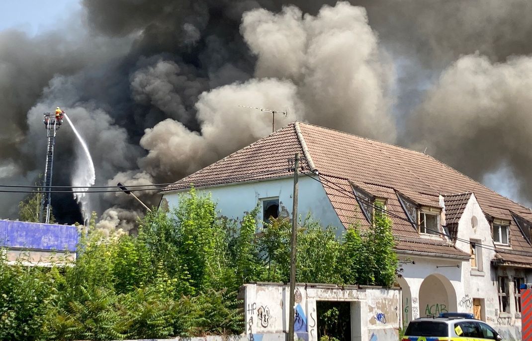 Auf dem alten Schlachthofgelände in Erfurt ist ein Feuer ausgebrochen und Rauch steigt in den Himmel. Anwohner:innen wurden vor Geruchsbelästigung gewarnt. Polizei und Feuerwehr sind vor Ort.