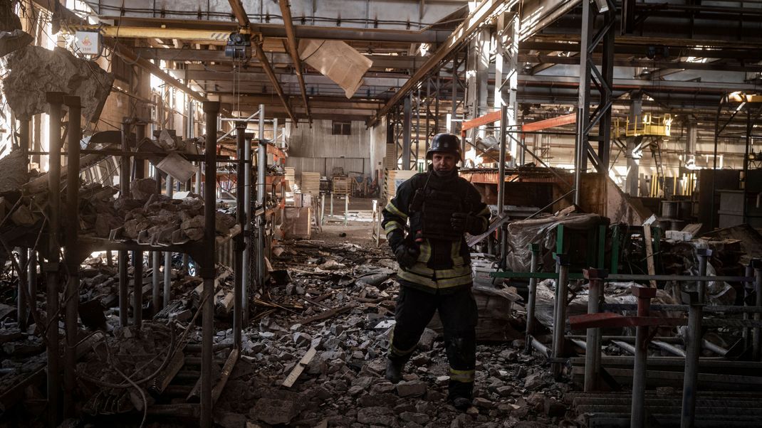 Einsatzkräfte in den Trümmern eines Industriegebiets nach einem russischen Bombenangriff.