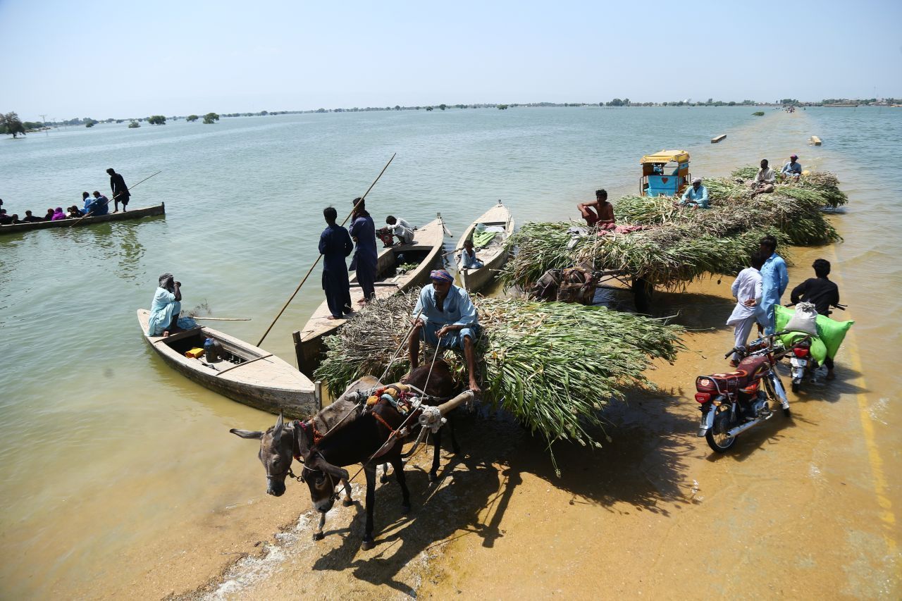 Wo mal eine Straße war, sind jetzt tausende Liter Wasser: Flutopfer bahnen sich in der Provinz Sindh einen Weg durch die Wassermassen. 