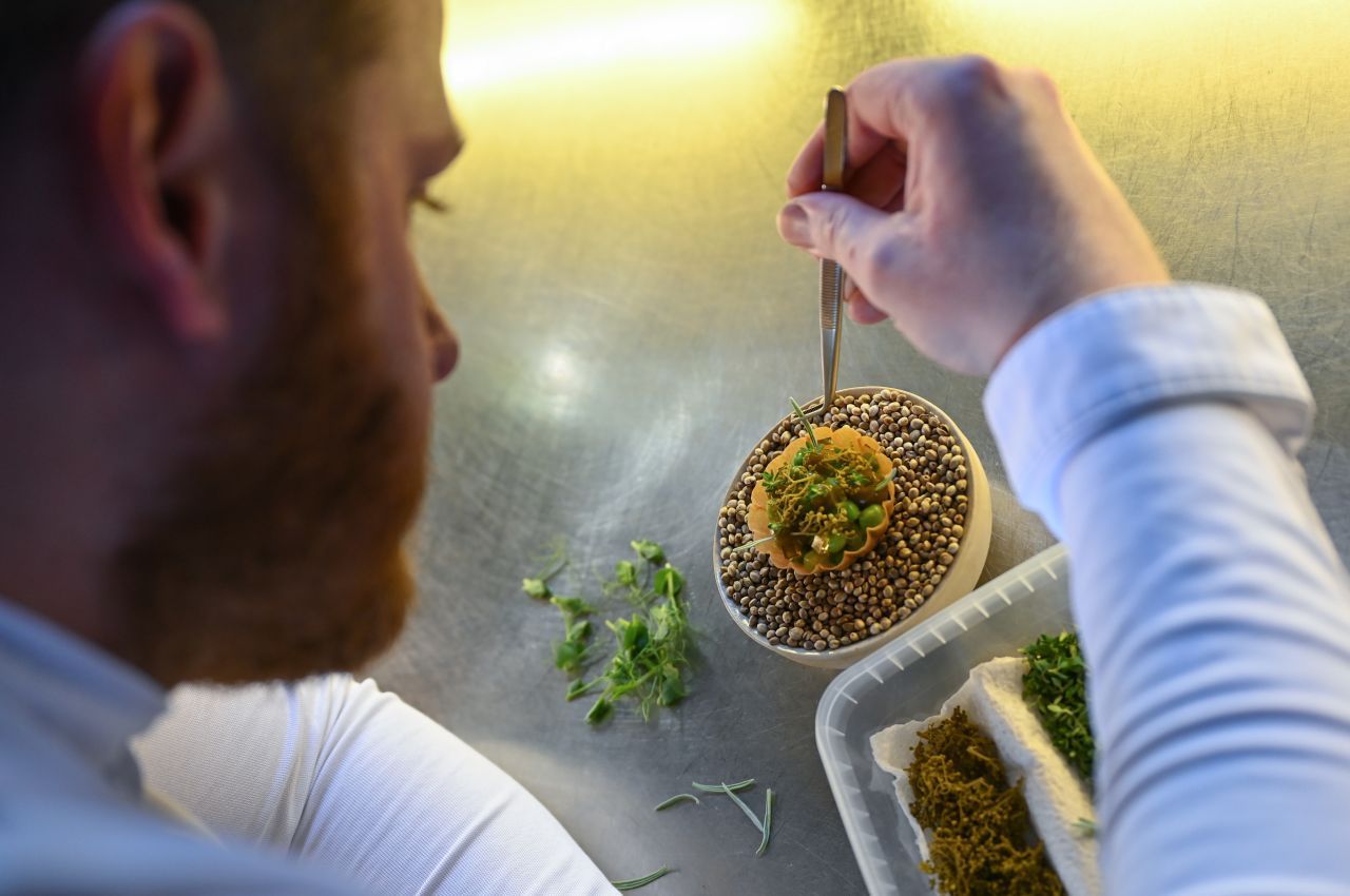 Sternekoch Ricky Saward bereitet im Seven Swans ein veganes Amuse-Bouche aus regionalen Produkten zu.