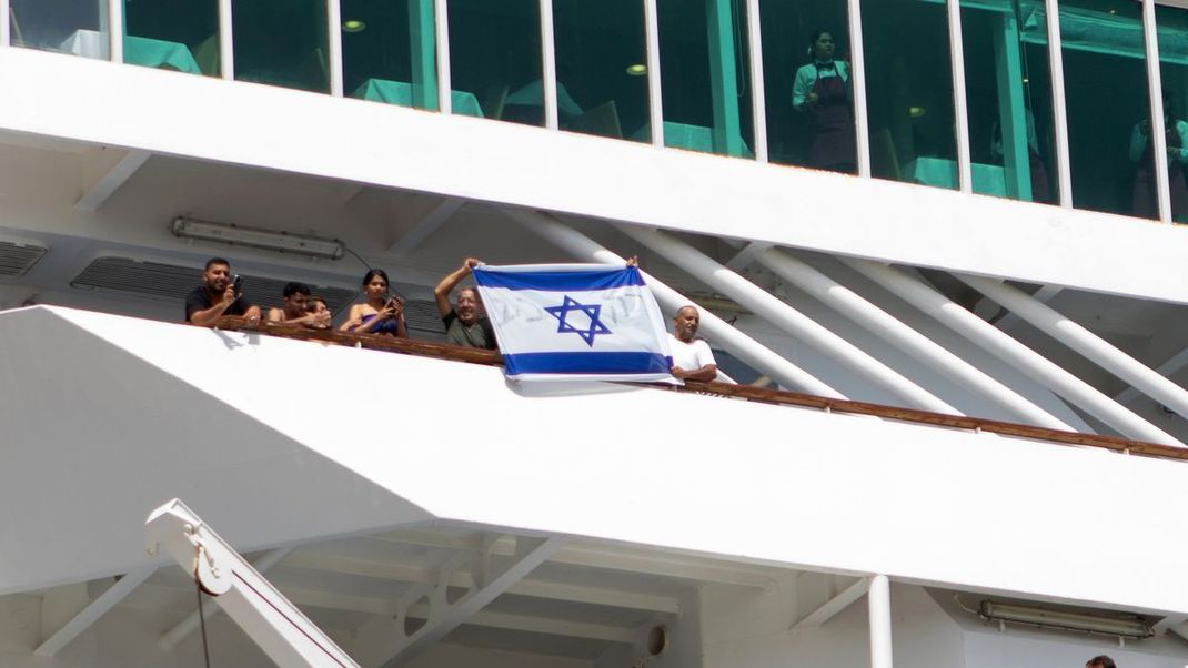 Ein letzter Gruß beim Ablegen von Rhodos: Israelische Touristen halten ihre Nationalflagge hoch.