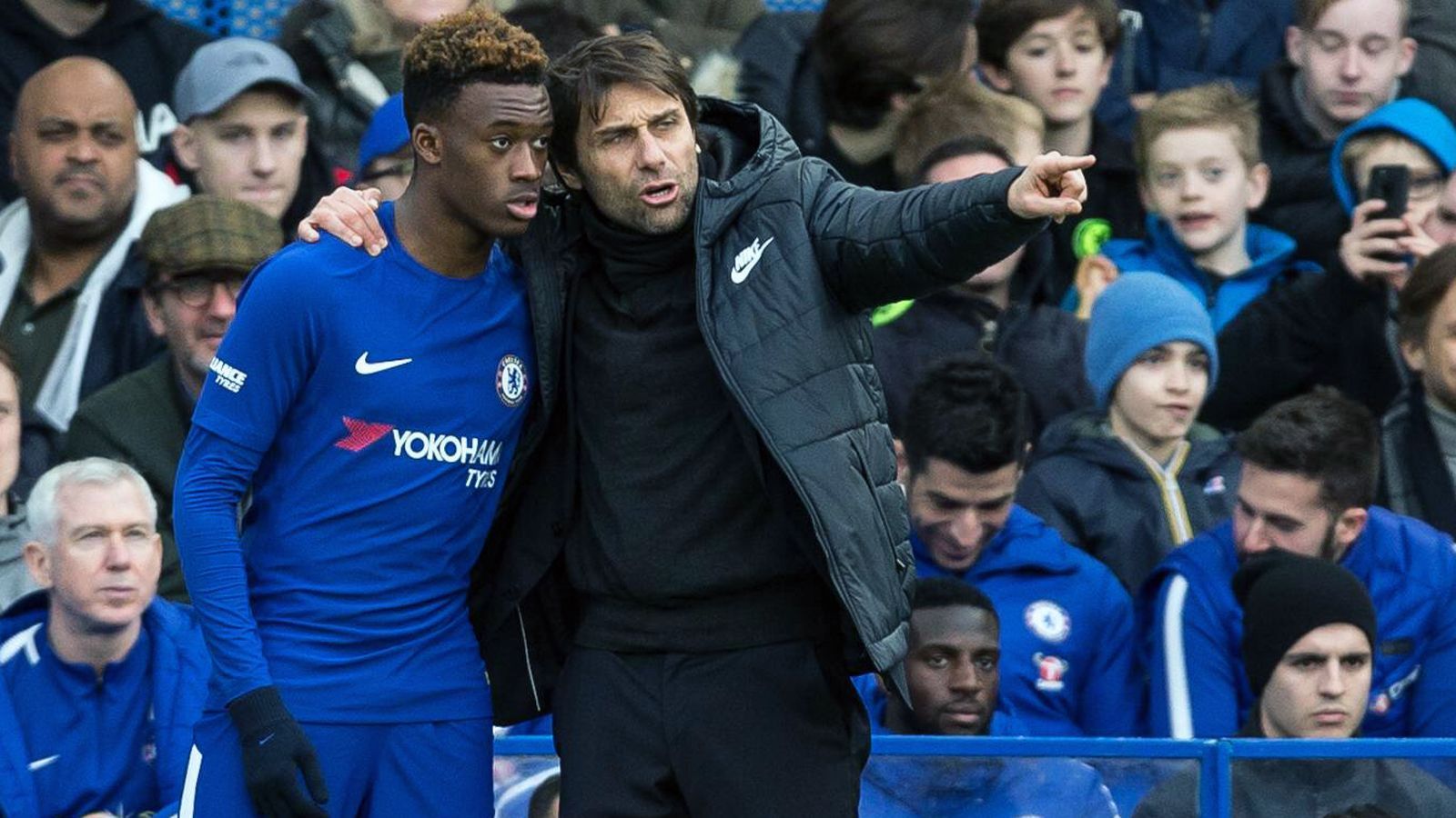 
                <strong>Förderer Conte</strong><br>
                Wenige Monate nach der Vertragsunterschrift verhalf Chelseas damaliger Trainer Antonio Conte (re.) dem Juwel Hudson-Odoi gleich innerhalb weniger Tage zu zwei Debüts. Zunächst durfte der Engländer am 28. Januar 2018 im FA Cup gegen Newcastle (3:0) erstmals für die Profimannschaft der Londoner auflaufen. Neun Minuten vor dem Ende kam Hudson-Odoi bei Chelsea für Pedro ins Spiel. 
              