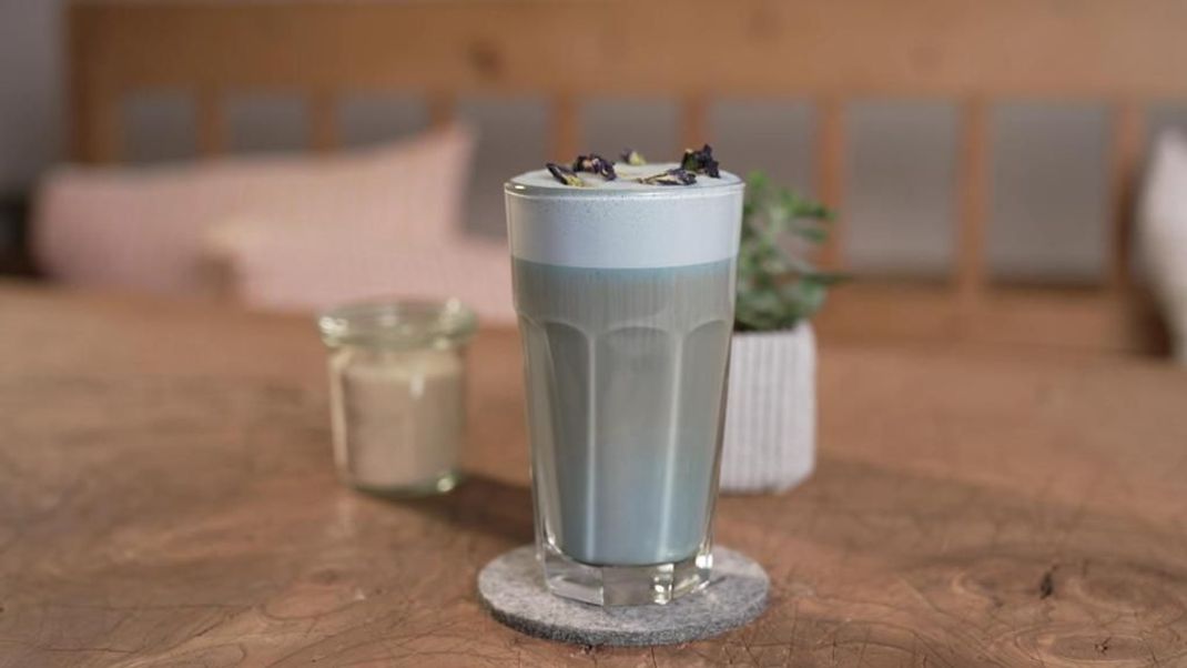 Blau wird der Drink dank der "Blue Pea Flower", zu Deutsch: Schmetterlingserbse. Die kannst du einfach im Internet bestellen. Eigentlich landet sie in Tee, kommt aber heute in den Kaffee! Die Kreation kommt aus Asien und ist dort schon länger hip. Je nach Gusto kannst du den Blue Pea Flower Coffee warm oder kalt genießen. 