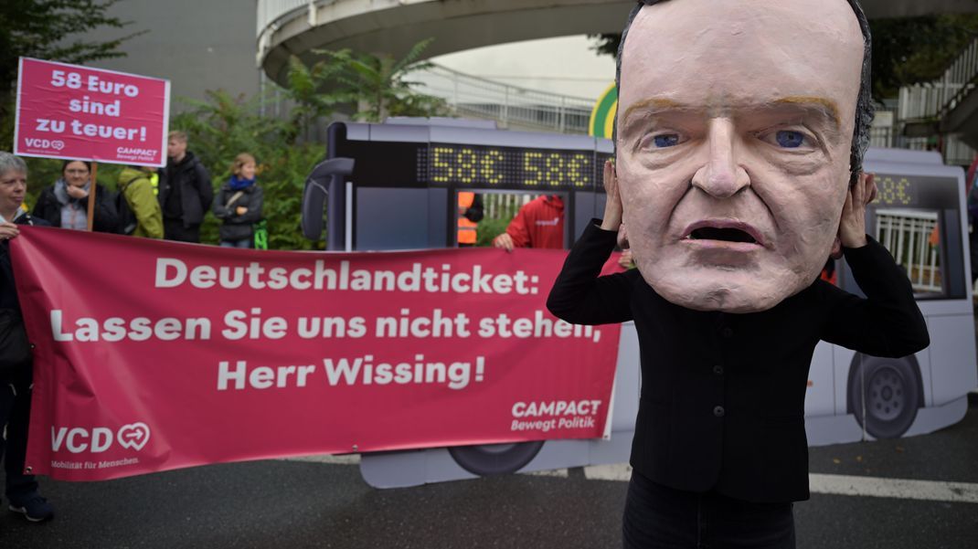 Ein Demonstrant trägt einen Pappkopf, der Volker Wissing (FDP), Bundesminister für Digitales und Verkehr, darstellen soll.