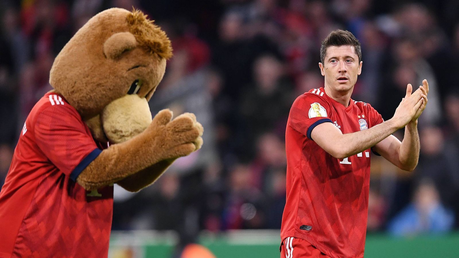 
                <strong>FC Bayern München: Die Maskottchen im Wandel der Zeit</strong><br>
                Berni hat die größten Stars Kommen und Gehen sehen. Hier verneigt er sich vor Robert Lewandowski. Oder ist Berni der eigentliche Star?
              