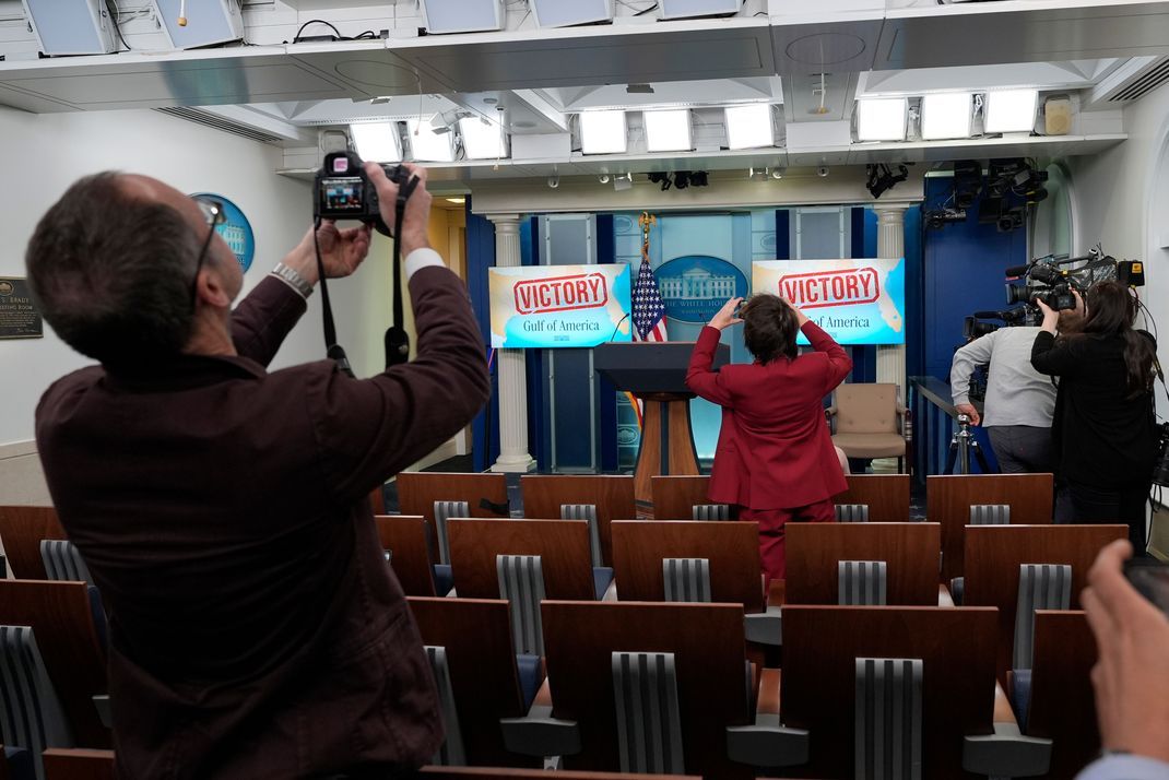 Menschen fotografieren die Monitore hinter dem Podium im James Brady Press Briefing Room im Weißen Haus in Washington. Auf den Bildschirmen ist "Sieg" und "Golf von Amerika" zu lesen.