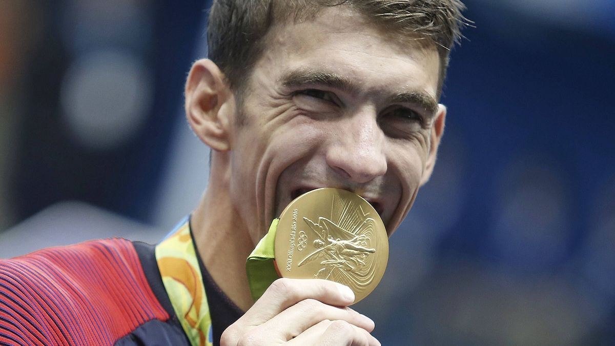 Michael Phelps zeigt seine Goldmedaille der Olympischen Sommerspielen 2016. imago images 1005349385