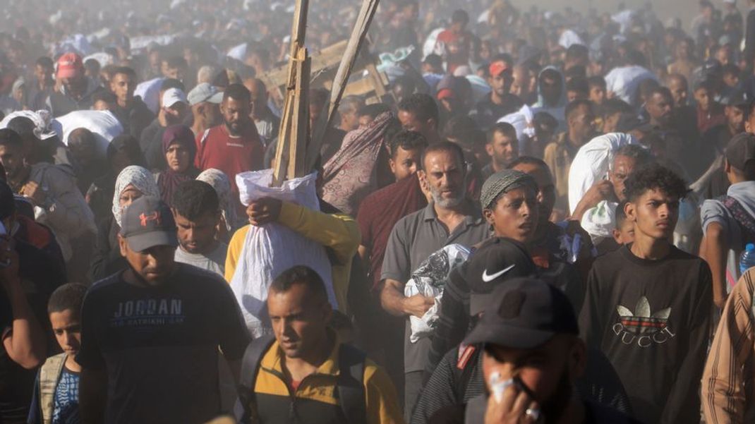 Palästinenser tragen Kisten und Taschen mit Lebensmitteln und humanitären Hilfspaketen - dabei sollen sieben von ihnen durch das israelische Militär getötet worden sein. 