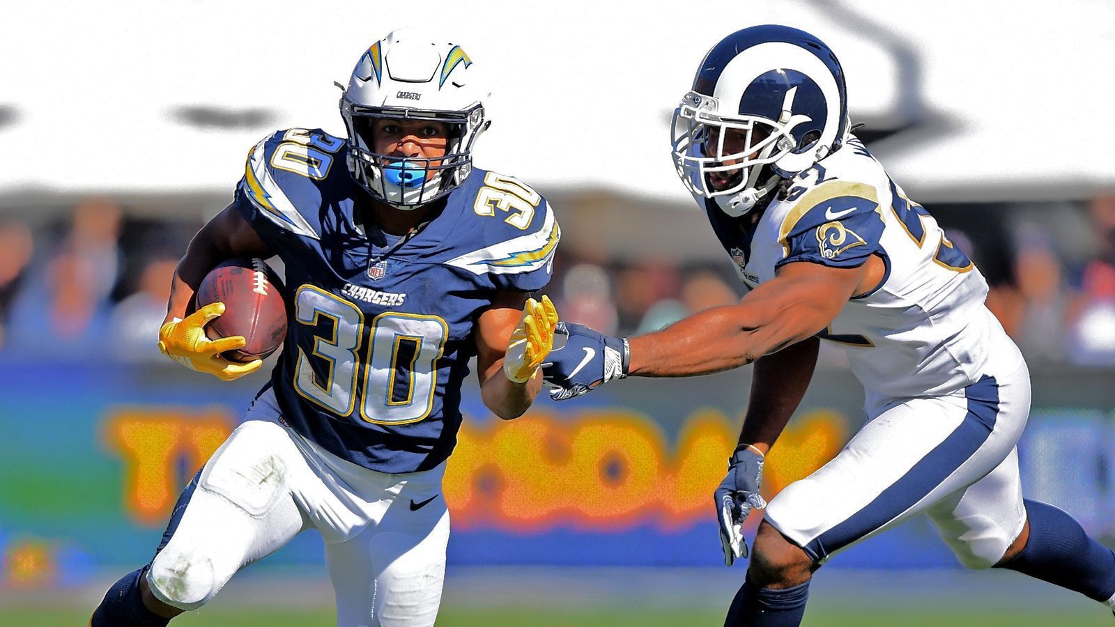 
                <strong>Rams at Chargers</strong><br>
                Mit den Los Angeles Chargers und den Los Angeles Rams begegnen sich im kommenden Training Camp zwei Teams, bei denen 2017 im Rahmen einer Joint Practice bereits die Fetzen flogen. Die Chargers, damals gerade von San Diego nach L.A. umgezogen, und die Rams lieferten sich auf dem Trainingsplatz eine Schlägerei um die Vormachtstellung in der Hollywood-Metropole. Nun, zwei Jahre später, ein neuer, hoffentlich friedlicherer Anlauf. Am 1. August stiegt die erste gemeinsame Einheit auf dem Gelände der Chargers, am 3. August sind die Rams die gastgebende Franchise.
              