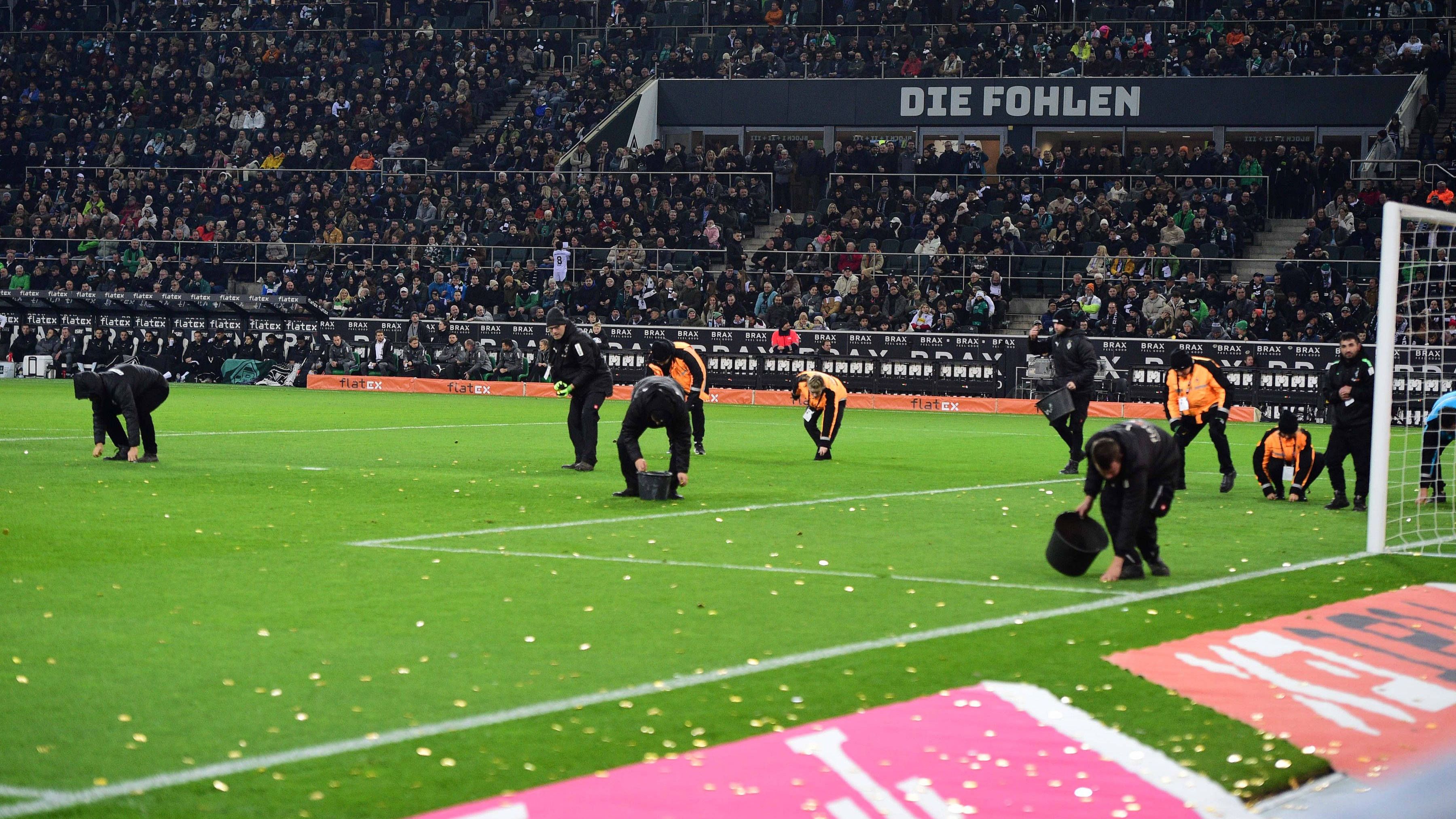 <strong>Gladbach: Schokotaler sorgen für Spielunterbrechung</strong><br>Die auf das Feld geworfenen Schokotaler sorgten dann auch dafür, dass die Begegnung für einige Minuten unterbrochen werden musste. Zahlreiche Helfer sowie auch einige Spieler waren damit beschäftigt, die Schokotaler vom Rasen zu entfernen.&nbsp;