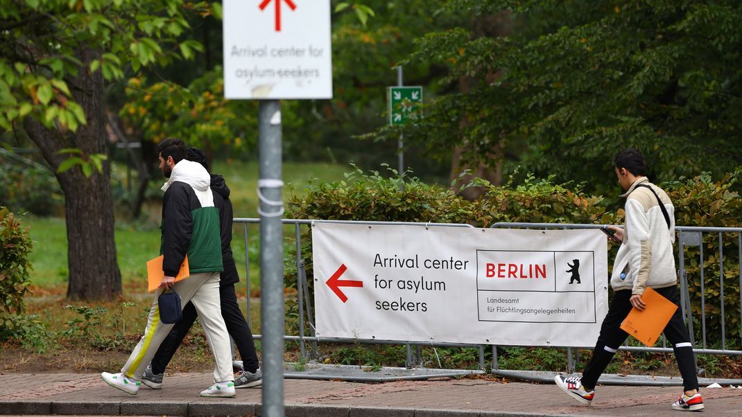 Migranten gehen zum Ankunftszentrum für Asylbewerber im Berliner Bezirk Reinickendorf.